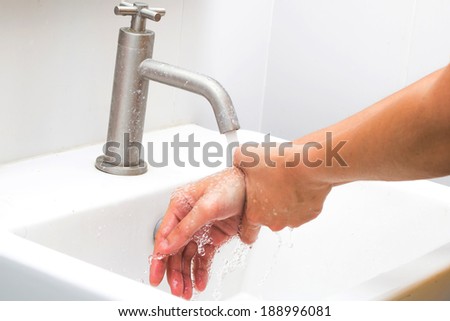 Washing of hands  under the crane with water