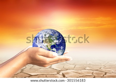 We love the world of ideas.world  in human hands.Cracked earth background. Elements of this image furnished by NASA.