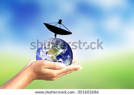 Satellite dish and earth in human hand.