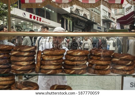 ISTANBUL, TURKEY - MAY 17, 2011: An old man stands in front of his carriage, in the streets of Istanbul, arranges his merchandise and sells bread rolls, in order to make a living out of it.