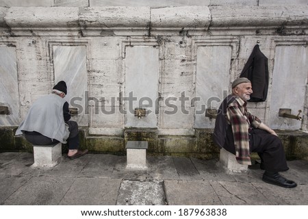ISTANBUL, TURKEY - MAY 18, 2011: Two old men wash their feet and hands on a fount outside of a mosque, before the daily praying takes place, as the religion of Islam commands.
