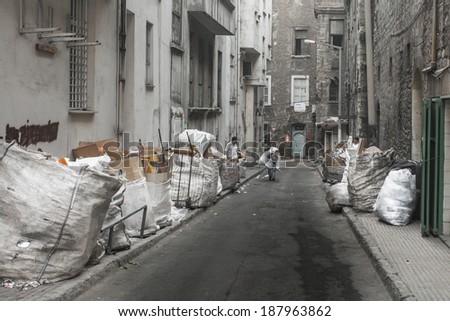 ISTANBUL, TURKEY - MAY 20, 2011: Young men carry big heavy sacks with recycled material, in order to sell what it\'s worth, even a bit, and to clean the streets filled with garbage.