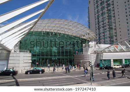 LISBON, PORTUGAL - MAY 26, 2014: People crossing in front of the Vasco da Gama Shopping Mall in Lisbon. The mall is decorated with an ocean theme, with water running over the transparent roof.
