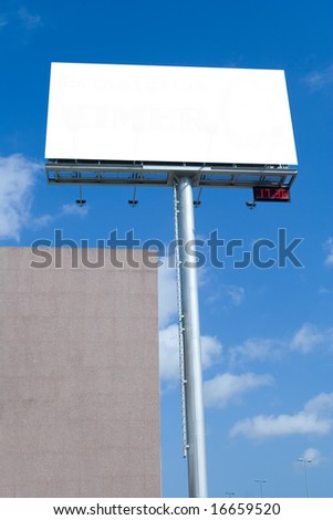 Blank billboard with digital clock against blue sky during rush hour