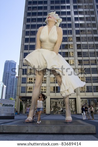CHICAGO - AUGUST 25: An unidentified tourist poses in front of a 26 foot tall sculpture of Marilyn Monroe in Chicago on August 25, 2011. Created by artist Seward Johnson, the work is on Michigan Avenue.