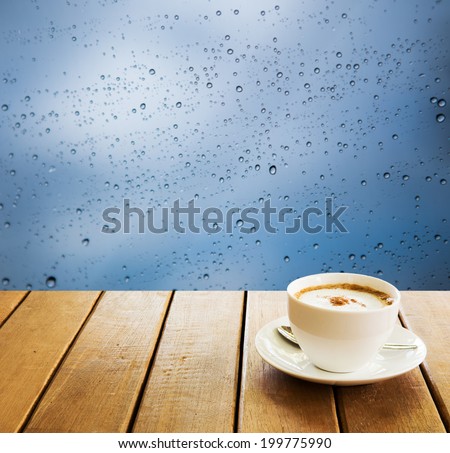 cup coffee on wooden table and Bokeh water drops  background