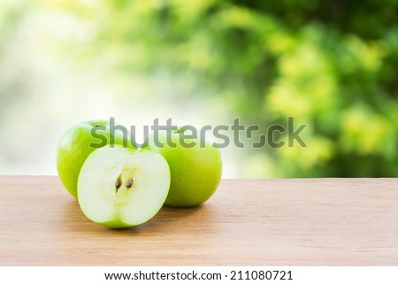 Green apple on wooden vintage table over bokeh background