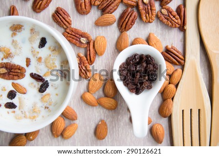 Sesame seeds with cereal breakfast almonds walnut raisin and milk.