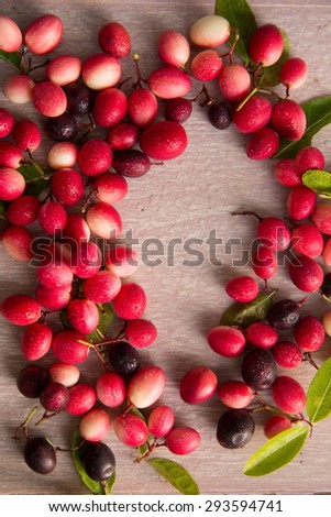 Carissa carandas fruits frame on wooden table