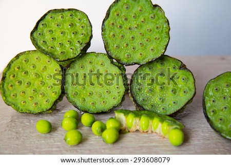 Lotus seed pod and young green seed on wooden table