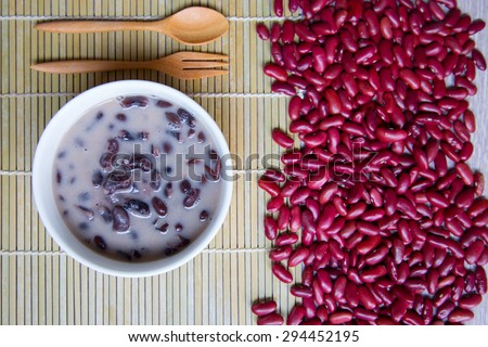 Red bean soup with coconut milk on wooden table decorated with red beans