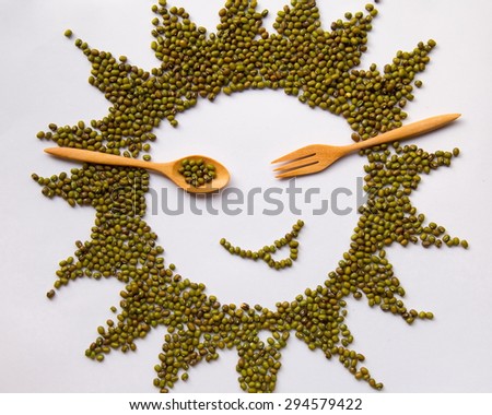 Yummy sun face of mung beans with wooden spoon and fork