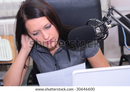 A radio DJ is in front of the mic in broadcasting studio
