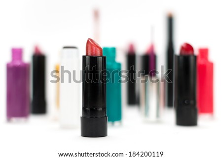 Various cosmetics and makeup products form arranged in front of a white background with shallow depth of field