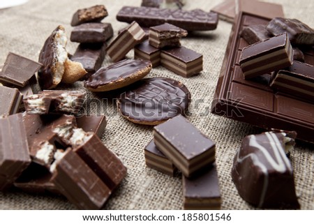 Broken chocolate bar and spices on wooden table
