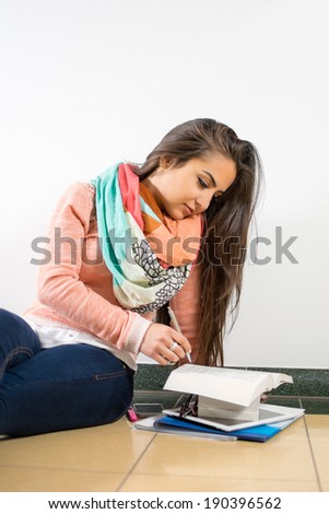 Portrait of a happy young woman with notebook, pen and glasses