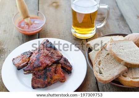 Spareribs on grill with hot marinade, czech beer and bread