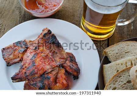Spareribs on grill with hot marinade, czech beer and bread