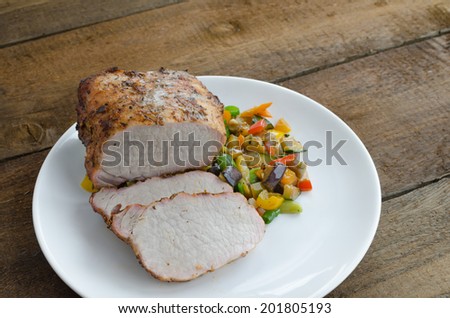 Pork roast on grill, sunny day, grilled mediterranean vegetables