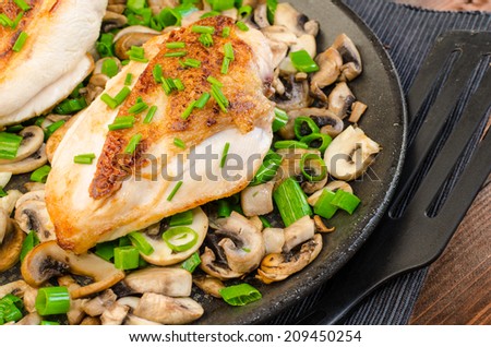 chicken breast with mushrooms and spring onions on pan