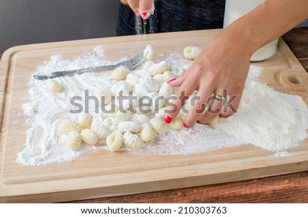 Making pasta gnocchi on wood plate with flour