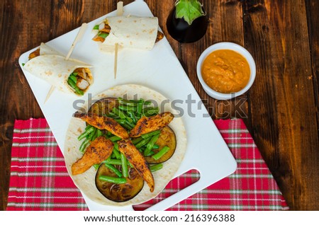 Chicken tortilla with beans and red curry on wood table