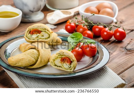 Home calzone rolls stuffed with cherry tomatoes, basil pesto and spinach with bio garlic