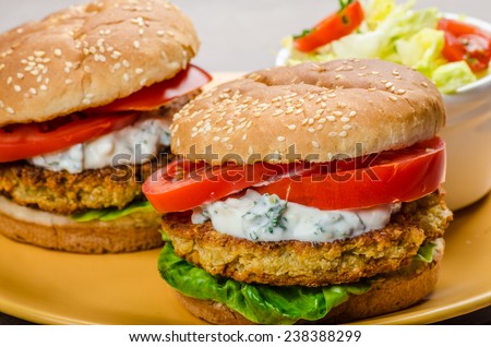 Vegetarian chickpea burger, tomato and dip of herbs, garlic and yogurt and salad with cherry tomatoes