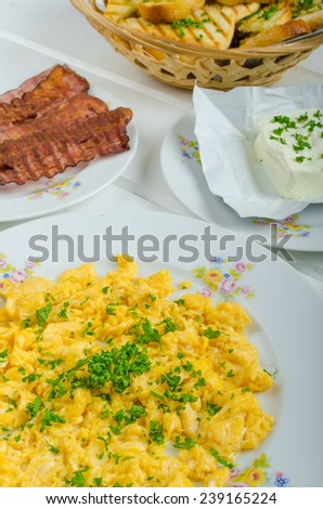 A hearty breakfast of eggs, bacon, sausage and toasted baguette and fresh curd
