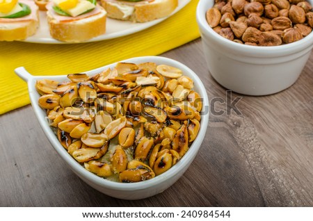 New Year\'s Eve meal - canapes with ham, cheese and spinach leaves, spicy cheese balls (Aigrettes), onion rings, roasted nuts with thyme and olive oil and beverages