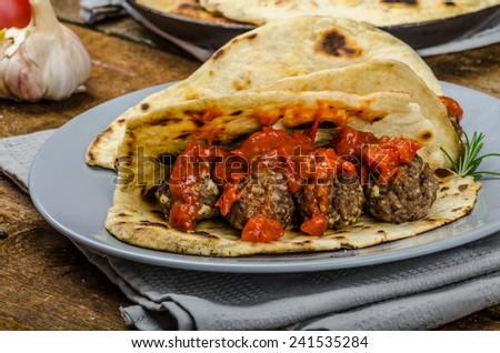 Indian naan with meatballs and tomato sauce, spicy sauce and exotic indian naan bread