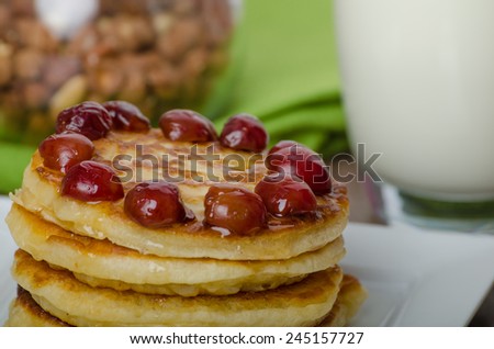 Home fluffy pancakes with cherry cherries and honey, milk drink