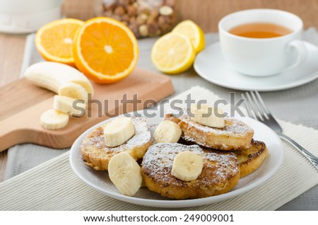 French toast to sweet, with banana sprinkled with sugar, fresh tea, breakfast