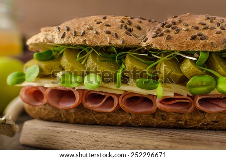 Baguette with the Prague ham, pickles, microgreens healthy herbs and emmental cheese