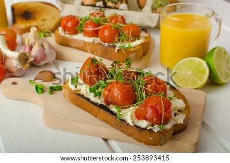 Roasted Cherry Tomato Sauce and Ricotta on Toast, fresh squeezed orange juice with lime, bio garlic and microgreens on tomato, baked with thyme