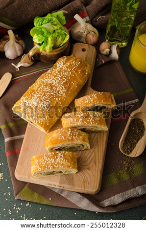 Roll out puff pastry stuffed with mushrooms, cheese and ham