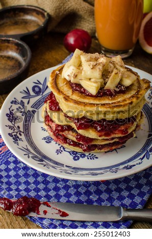 Homemade pancakes with jam and bananas with chocolate on top, grapefruit juice