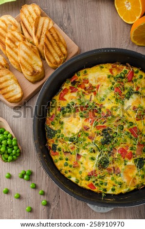 Vegetarian frittata with spinach, prosciutto and microgreens, fresh crispy baked baguette flavored with fresh pepper and olive oil