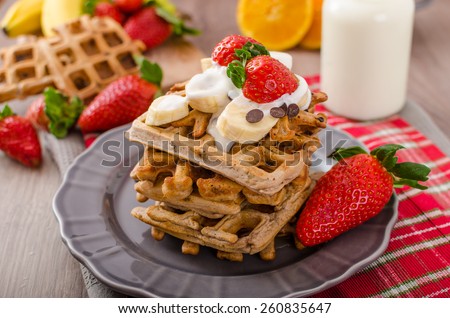 Belgian waffles with chocolate, bananas and strawberries, syrup-drenched