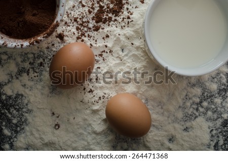 Home eggs, flour and cocoa powder, product photo, beautiful lighting