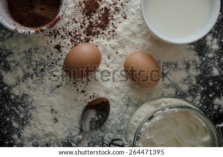 Home eggs, flour and cocoa powder, product photo, beautiful lighting