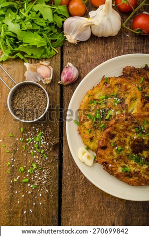 Fried potato pancakes with garlic and marjoram, sprinkled cumin, chive and coarse-grained salt