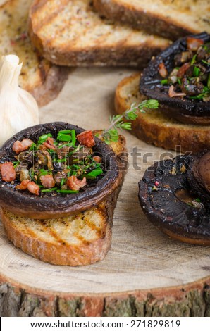 Portobello stuffed with herbs, bacon and garlic, delicacyon toasted crusty garlic bread