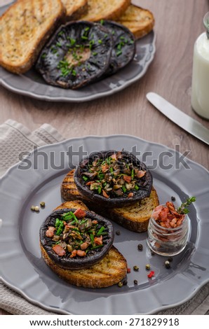 Portobello stuffed with herbs, bacon and garlic, delicacyon toasted crusty garlic bread