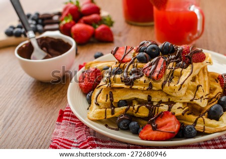 Belgian waffles with blueberries, strawberries covered with chocolate