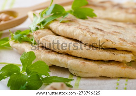 Lebanese bread, pita bread, nice and fresh chickpeas in background, simple cheap bread with herbs and garlic
