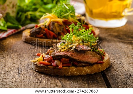 Devilish fried bread with peppers, chilli and beef steak, topped cheddar cheese and microgreens, with czech beer