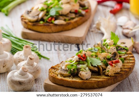Toast with mushrooms and fried chicken, sprinkled with fresh herbs, little spicy from garlic and chilli, fresh juice