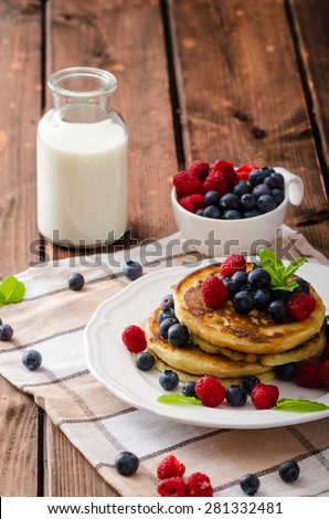 Pancakes with forest fruit and mint, fresh fruits and milk