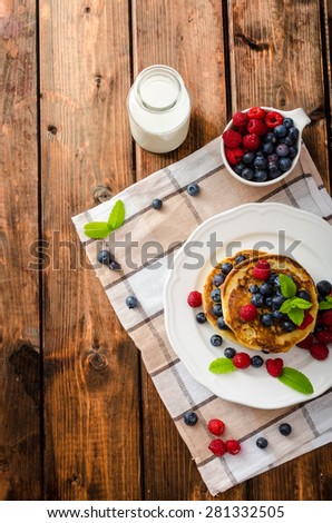 Pancakes with forest fruit and mint, fresh fruits and milk